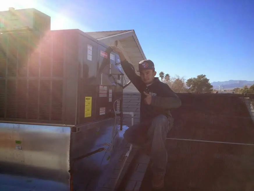 HVAC technician performing AC Tune-Up on a rooftop unit in North Olmsted
